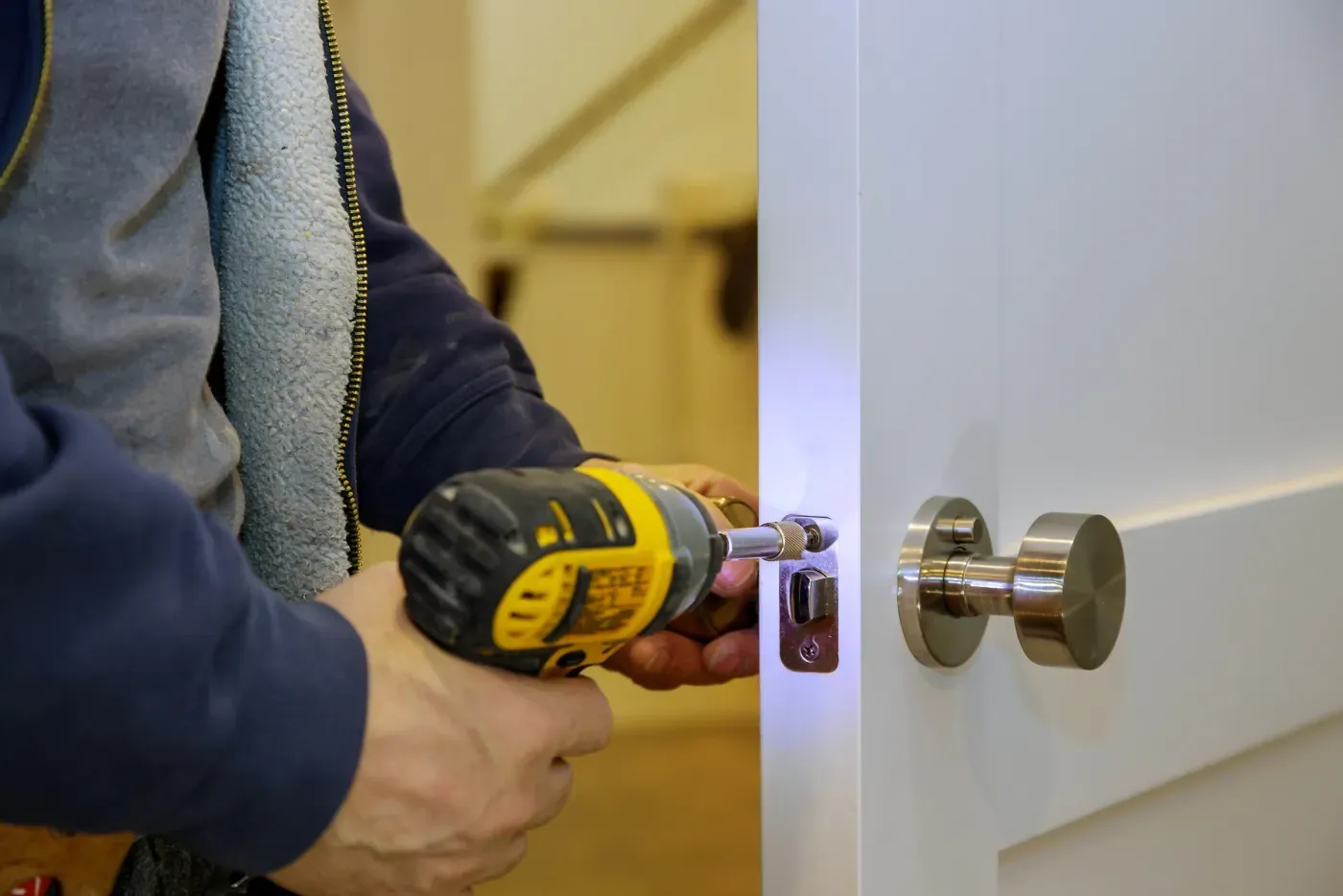 Artisan de notre équipe posant une serrure multipoints sur une porte en Île-de-France